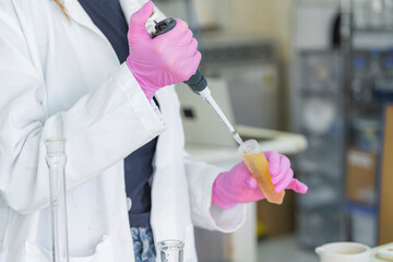 Scientist using pipette to transfer liquid in laboratory