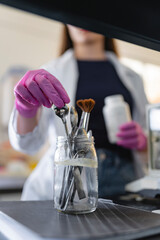Close up of female scientist cleaning laboratory tools in glass jar
