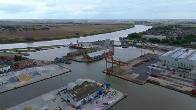 Aerial drone view of busy shipping port, industrial buildings and wharfs for loading and unloading cargo ships and tankers near Goole, United Kingdom
