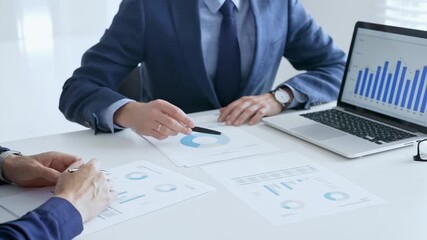 Business team of several colleagues discussing financial data on a laptop while analyzing charts and market trends in office. Businesspeople and finance concept - Powered by Adobe