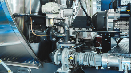 A machine with a lot of pipes and valves. The pipes are black and the valves are silver