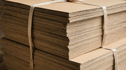Bundled stack of flat cardboard sheets used for box making in warehouse logistics