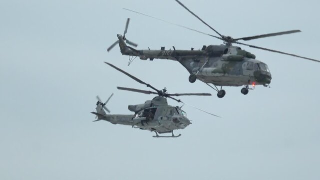 Helicopters execute synchronized aerial maneuvers above training grounds