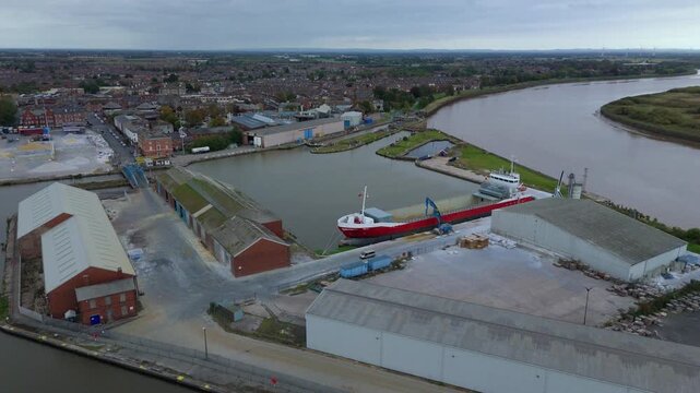 Aerial drone view of busy shipping port, industrial buildings and wharfs for loading and unloading cargo ships and tankers near Goole, United Kingdom
