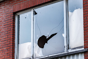 Damaged window glass after vandalism incident shows need for repair and security following a break in at a home or business, conveying vulnerability and property crime