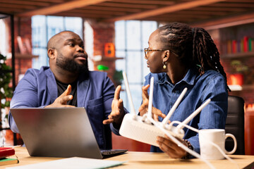 Irritated black couple getting angry over Wi Fi signal loss during remote work, trying to reboot...