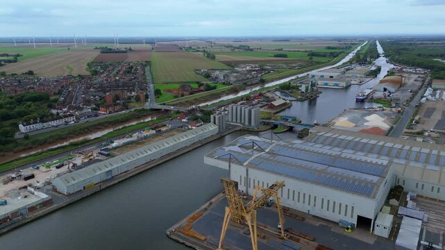 Aerial drone view of busy shipping port, industrial buildings and wharfs for loading and unloading cargo ships and tankers near Goole, United Kingdom