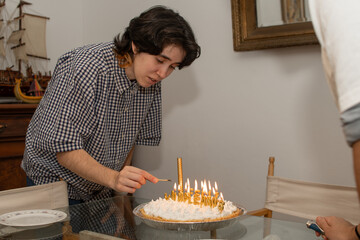 Mujer joven encendiendo velas en pastel de cumpleaños