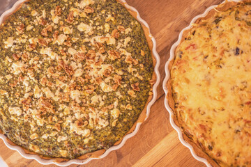 Savory vegetable quiches with nuts cooling on a wooden countertop in a cozy kitchen setting