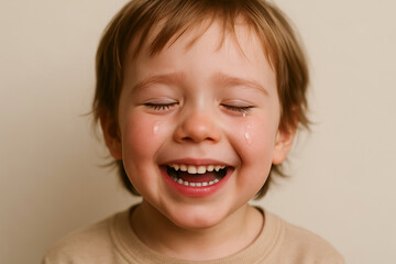 Joyful child with tears of happiness smiling brightly indoors. concept of childhood emotions, joyful expression, innocent happiness