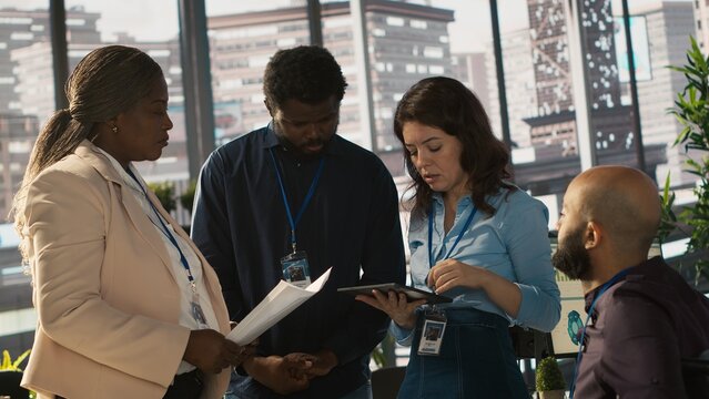 Employee with paraplegia and colleagues in inclusive office brainstorming, reviewing financial charts, analyzing KPIs. Person with paraplegia and team coworkers colleagues comparing data, camera A