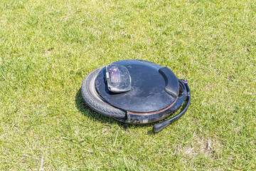 Electric unicycle leaning on the green grass background