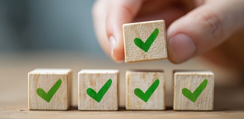 A hand places a small wooden block with a green check mark on top of other blocks