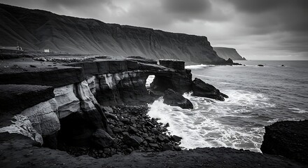 Dramatic black and white coastal landscape with rocky cliffs and ocean waves
