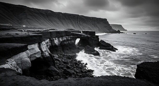 Dramatic black and white coastal landscape with rocky cliffs and ocean waves