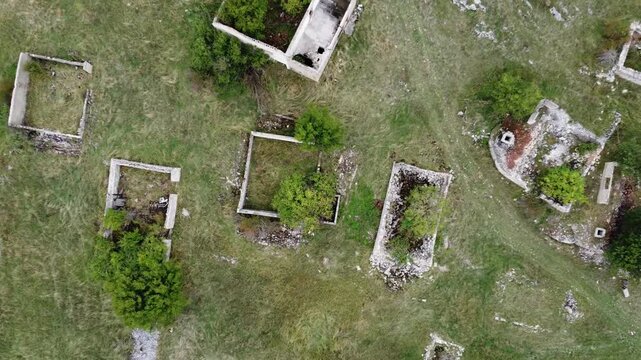 Destroyed village in war, aerial drone view. Ruined and damaged house in village as war aftermath. Houses destroyed and burned by artillery during the war. Houses in ruins. 