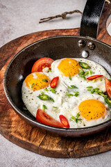 Fried eggs with tomatoes and chili peppers