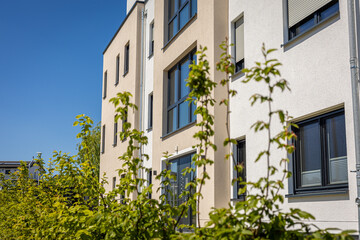 Modern apartment building surrounded by vibrant greenery on a sunny day