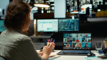 Executive manager interacting in a webinar video call for briefing, sharing latest report data after hours in the office. Collaborative meeting on web conference at midnight. Camera B.