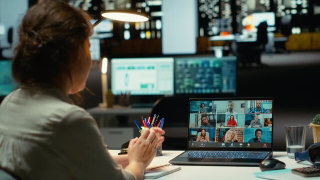 Executive manager interacting in a webinar video call for briefing, sharing latest report data after hours in the office. Collaborative meeting on web conference at midnight. Camera B.
