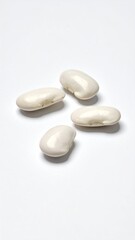 Four lima beans scattered on white
