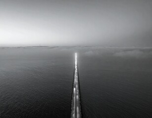 Fototapeta premium Pier stretches into a moody, foggy horizon above water