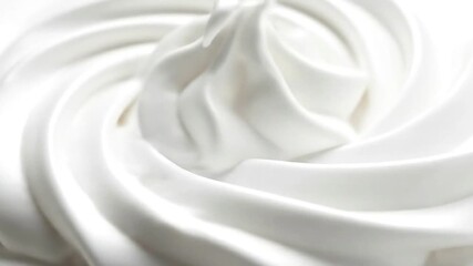 Close-up of luscious white whipped cream with soft swirls, perfect for desserts and toppings.