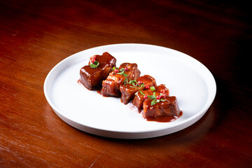 plate of sliced ​​pancetta gourmet meat served with sauce and spices on wooden table