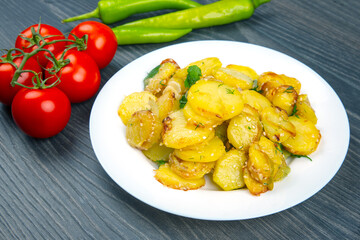 Delicious potato dish served with fresh vegetables on wooden table