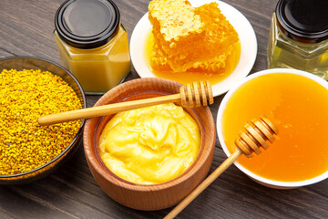 Honey products displayed with jars and honeycomb on wooden surface at a local market