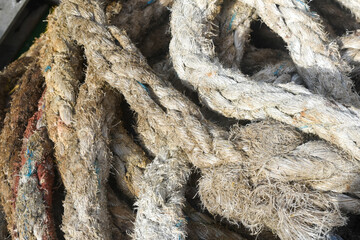 A close up view of a large pile of thick twisted natural fiber ropes	
