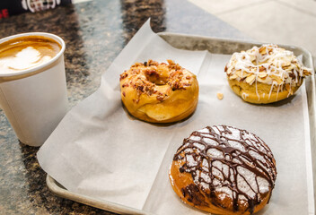 Nutella latte with a toasted coconut almond doughnut, salted caramel bacon doughnut, and Nutella-filled cream puff in Decatur Georgia