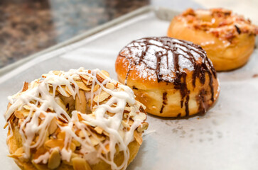 Toasted coconut almond doughnut, salted caramel bacon doughnut, and Nutella-filled cream puff in Decatur Georgia