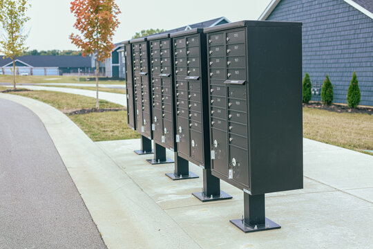 Community mailboxes on suburban street. Modern black cluster mailboxes for residential neighborhood delivery service in USA.