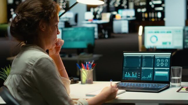 Woman accounting specialist reviews archived reports data for future strategy, using digital charts to plan resources allocation and align business goals with financial development. Camera B.
