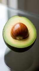 Close-up of a halved avocado, showcasing the vibrant green flesh and seed, perfect for healthy eating