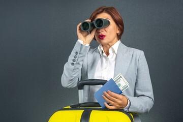 Businesswoman preparing for travel while looking through binoculars