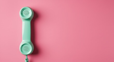Retro mint green telephone receiver on pink background concept