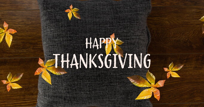 Fototapeta Image of happy thanksgiving text over fall leaves and pillow