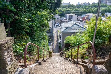 神社から下る長く細い石段と遠景の街並み