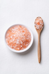 Top view of Himalayan pink salt in bowl with spoon on white background, Healthy food ingredient