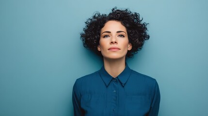 Confident Woman with Curly Hair Against a Blue Background