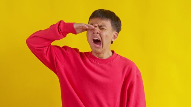 Casual Young man expressing yawn feeling tired  isolated in yellow background