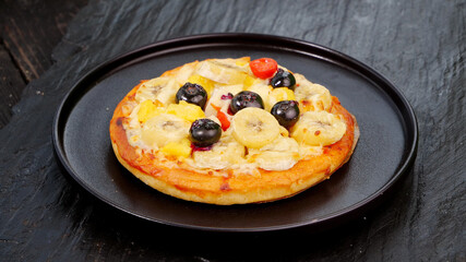 Sweet Dessert Pizza with Banana and Blueberry Toppings on Dark Plate