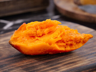 Fresh Cut Sweet Potato with Orange Flesh on Wooden Cutting Board