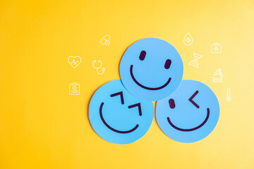 Mental wellness concept with blue happy face healthcare symbols, representing emotional health, positive thinking, self care, mood, and wellbeing.