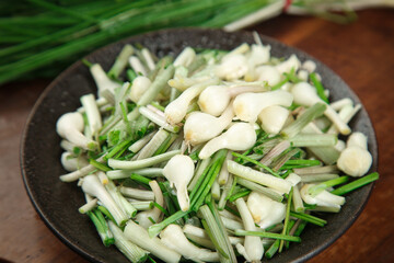 Fresh Wild Mountain Onions with Rootlets from Jiangxi China on Dark Plate