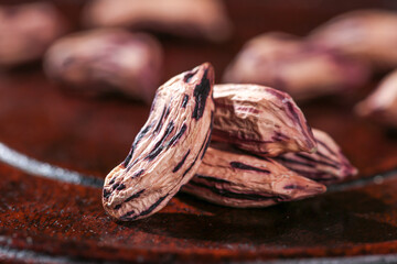 Deflated Dried Bean Pods with Colorful Striped Patterns on Rustic Wooden Background