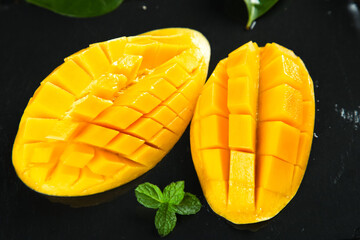 Fresh Sliced Mango Halves with Mint Leaves on Dark Background - Tropical Fruit Photography