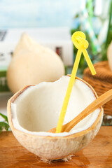 Fresh Coconut Half with Yellow Straw on Wooden Table - Tropical Healthy Drink Concept